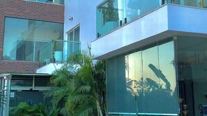 A modern multi-story building with large glass windows and balconies. - Wallgate Apartments (Abuja)