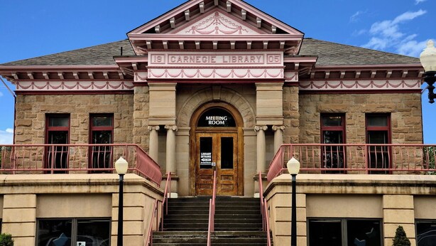 A historic building with a prominent entrance labeled "Meeting Room" and "Library Entrance."