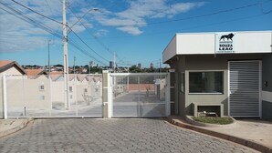 A gated residential complex named "Residencial Souza Leão" with a paved entrance and a view of the cityscape in the background. - Hospedagem Mobiliada (Tupa)