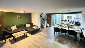 Una sala de estar moderna con sofá, mesa de centro y comedor con sillas y una mesa.