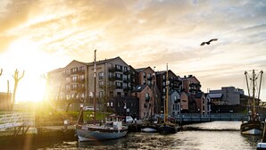 Un puerto con barcos, un faro y edificios residenciales.