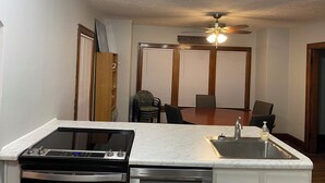 Una cocina compacta con estufa integrada, un lavamanos y un ventilador de techo.