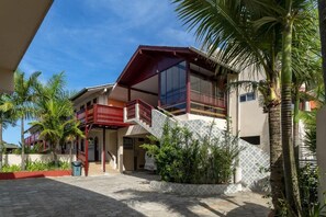 A two-story building with a balcony, a staircase, and a tiled exterior. - Suíte Ala pôr do sol Residencial Solavir (Bombinhas)