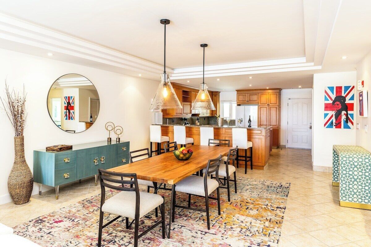 Een moderne keuken met houten kasten, een centraal eiland en hanglampen.