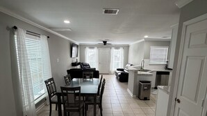 A spacious living area with a dining table and chairs, a kitchen with a sink and cabinets, and a ceiling fan. - Comfortable and safe family lodging for everyone close to the medical center.  (Houston)