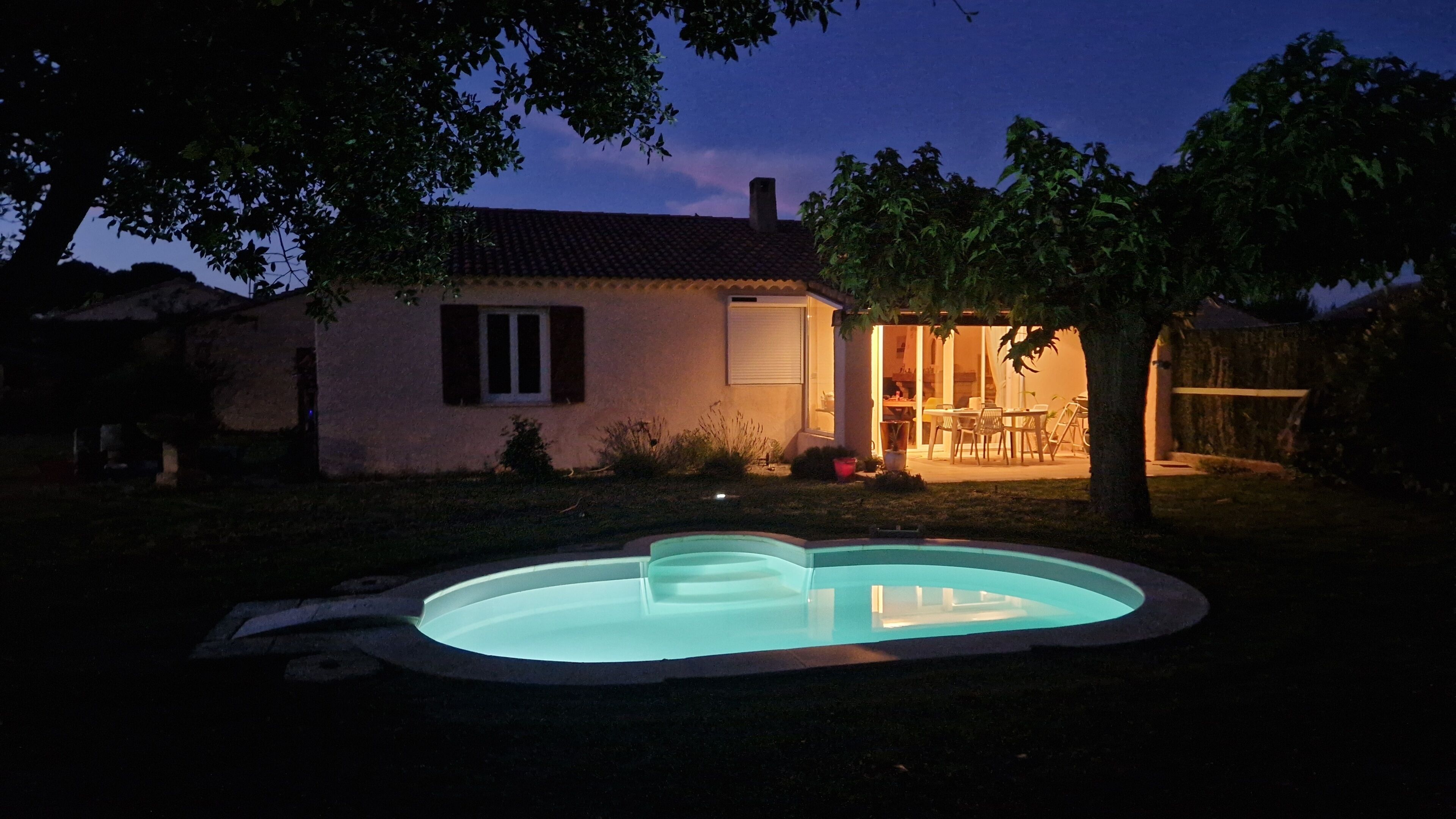 Ein Haus mit Schwimmbad, Terrasse und Essbereich.
