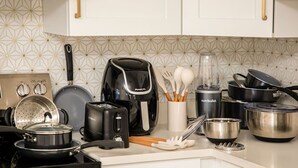 A kitchen with white cabinets, a stove, a toaster, a blender, and various pots and pans. - `The Morning Star` w/ spa & Private Mini Beach (Naples)