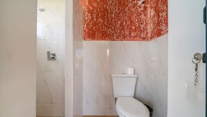 Een badkamer met toilet, douche en wastafel.