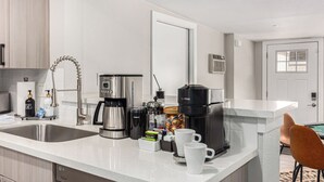 A modern kitchen with a stainless steel sink, a coffee maker, and a coffee machine. - 3BR Southwest Modern Haven - Old Town (Scottsdale)