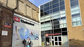 A building with a large mural of a face and abstract patterns, a sign for 'Chelmsford', and a modern glass entrance. - Central Chelmsford 2-bed Apt, 5 Mins to Station (Chelmsford)