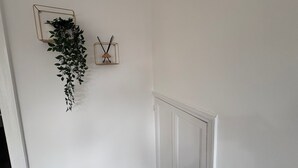 A white door with a white wall and a hanging plant. - Central Chelmsford 2-bed Apt, 5 Mins to Station (Chelmsford)