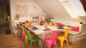 A dining area with a wooden table set for six, surrounded by colorful chairs. - Magnificent Festive Loft (Saint-Pourçain-sur-Sioule)