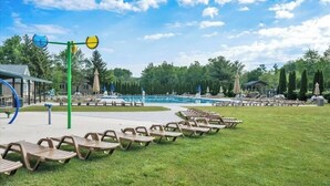 A pool area with lounge chairs, a play structure, and a covered seating area. - OpenConcept Cinema KingBed HotTub Sauna FirePit Pickleball Arcade Spacious (Coolbaugh Township)