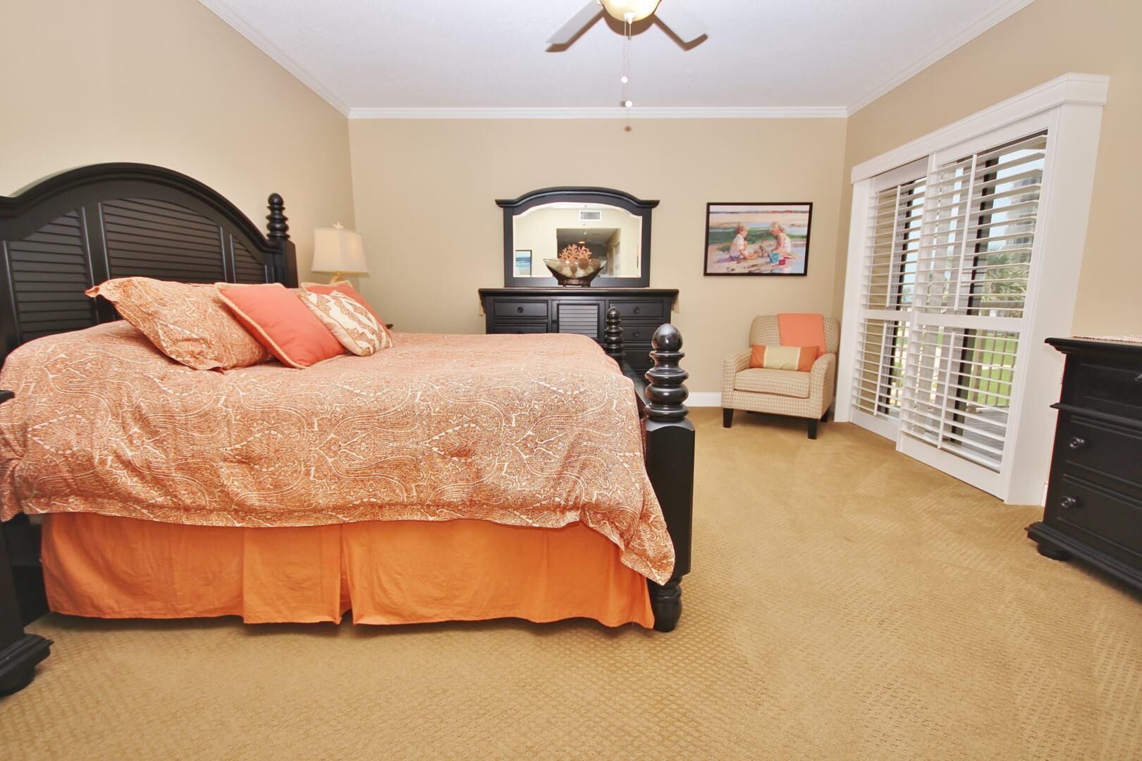 A bedroom with a bed, dresser, chair, and window with blinds.