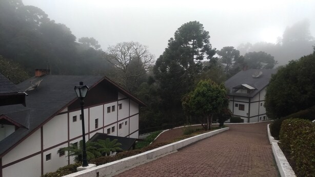 A traditional building with a steeply pitched roof, a brick pathway leading up to it, and a lamppost in the foreground. - Apartment in Morro do Elefante Campos do Jordão (Vila Floresta Campos do Jordão)