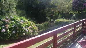 A garden with a red metal railing and a bench. - Apartment in Morro do Elefante Campos do Jordão (Vila Floresta Campos do Jordão)