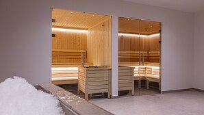 Een sauna met houten banken en een glazen scheiding.