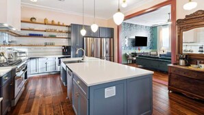 Una cocina moderna con una isla central, electrodomésticos de acero inoxidable y suelo de madera.