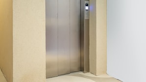 A modern elevator with a control panel, set in a minimalist interior with plain walls and a light-colored floor. - Cosy a few Steps From Copacabana Beach Q16 (Rio de Janeiro)