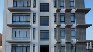 A modern multi-story building with a symmetrical facade, large windows, and a flat roof. - Nma a Residences 2 (Riyadh)