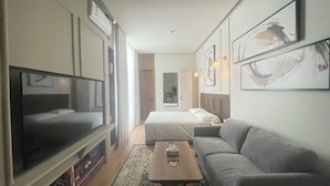 A hotel room with a bed, a sofa, a TV, and artwork on the walls. - Nma a Residences 2 (Riyadh)