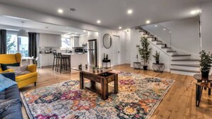 A modern apartment with a kitchen, dining area, and living room. - Lux. 4BR House with Pool near DT (Brossard)