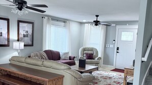 A living room with a sofa, armchair, coffee table, and a ceiling fan. - Charming 4-bedroom, all new-century old treasure, located near Mercy hospital (Aurora)