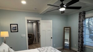 A bedroom with a bed, a ceiling fan, a door, a mirror, and a window with curtains. - Charming 4-bedroom, all new-century old treasure, located near Mercy hospital (Aurora)