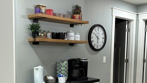 A kitchen with wooden shelves holding kitchenware, a coffee maker, and a clock on the wall. - Charming 4-bedroom, all new-century old treasure, located near Mercy hospital (Aurora)
