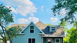 A two-story house with a gabled roof, a front porch, and a small attached garage. - Charming 4-bedroom, all new-century old treasure, located near Mercy hospital (Aurora)