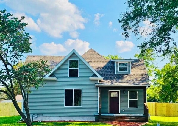 A two-story house with a gabled roof, a front porch, and a small attached garage. - Charming 4-bedroom, all new-century old treasure, located near Mercy hospital (Aurora)