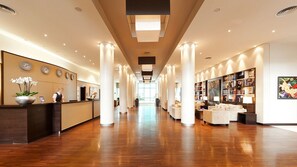 A spacious lobby with a reception desk, a bookshelf, and a seating area. - Abion Villa Suites (Berlin)