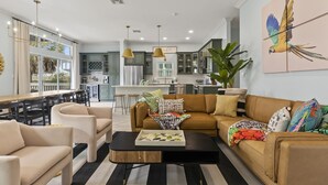 A modern living room with a sofa, coffee table, and dining area.