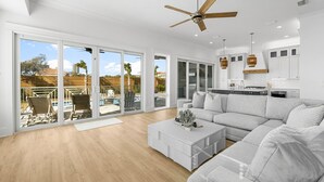 A spacious living room with a large sectional sofa, a coffee table, and a ceiling fan. - Tango Vista With Pool, Elevator, And Beach Views (Miramar Beach)