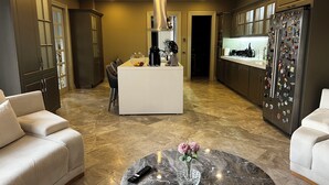 A modern kitchen with a central island, dark cabinetry, and a refrigerator adorned with magnets. - Lüks villa (İstanbul)