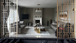 A modern living room with a fireplace, sofas, a coffee table, and decorative vases. - Lüks villa (İstanbul)