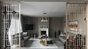 Een moderne woonkamer met een open haard, banken, een salontafel en decoratieve vazen.