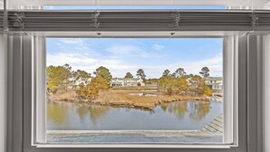 A window with a view of a pond, trees, and houses. - NEWLY RENOVATED - Mallard Lakes - Rare 3 bedroom unit near Fenwick & OC. (Selbyville)