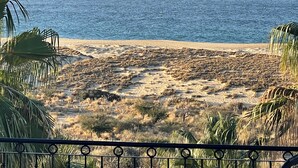 A beach with dry vegetation and a clear view of the ocean. - Novaispania Pueblo Bonito Sunset Beach (Cabo San Lucas)