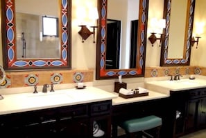 Un baño con dos lavamanos, un espejo y un perchero para toallas.