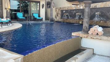 Una piscina al aire libre, sombrillas, tumbonas