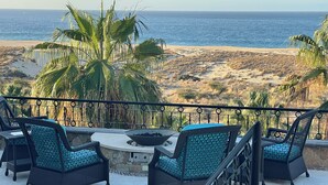 A patio with wicker furniture and a fire pit overlooking a beach. - Novaispania Pueblo Bonito Sunset Beach (Cabo San Lucas)