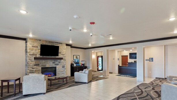 A spacious lobby with a stone fireplace, comfortable seating, a reception desk, and a flat-screen TV. - Cobblestone Hotel & Suites - Ephraim (Ephraim)