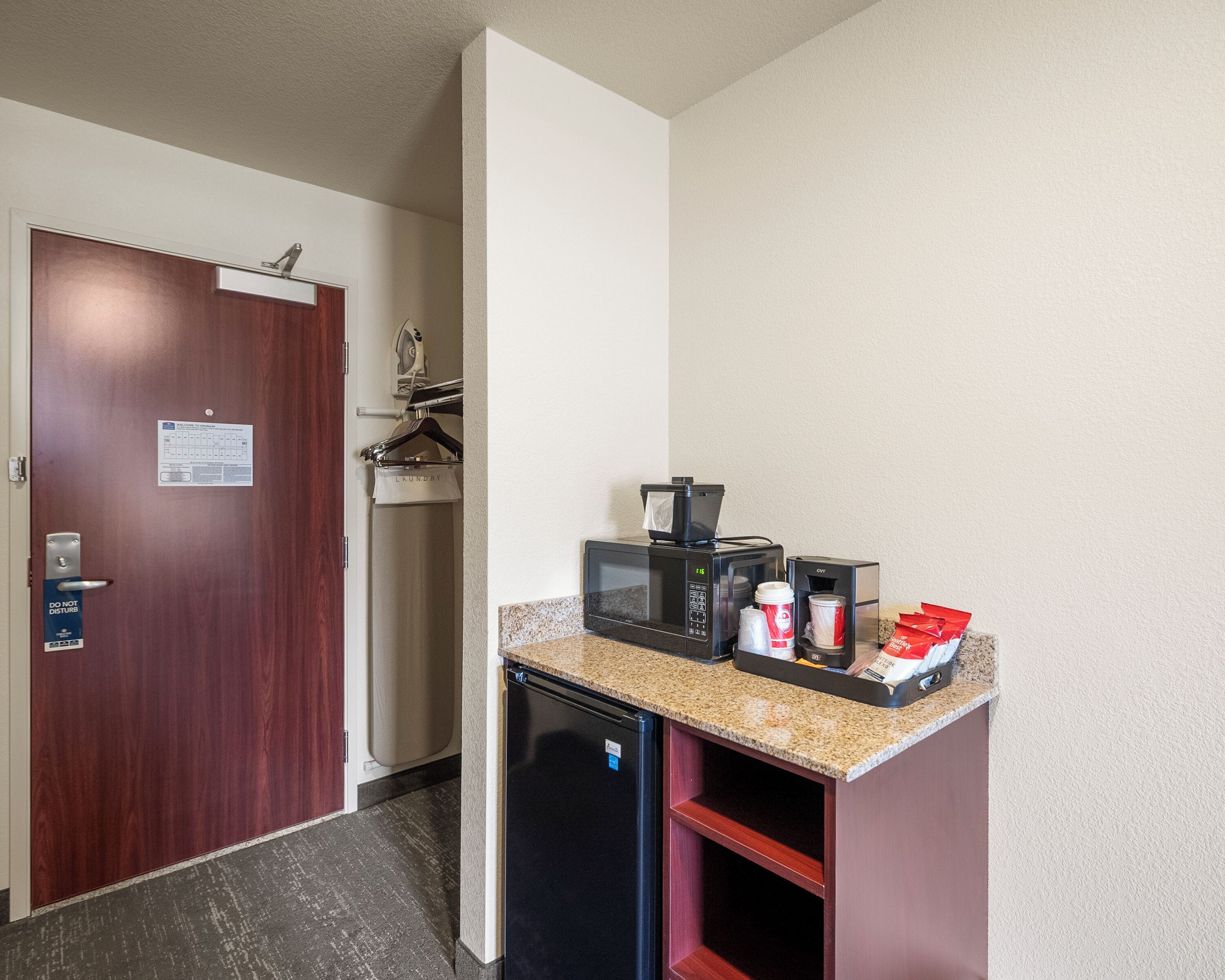 A compact kitchenette with a microwave, coffee maker, and a small refrigerator.