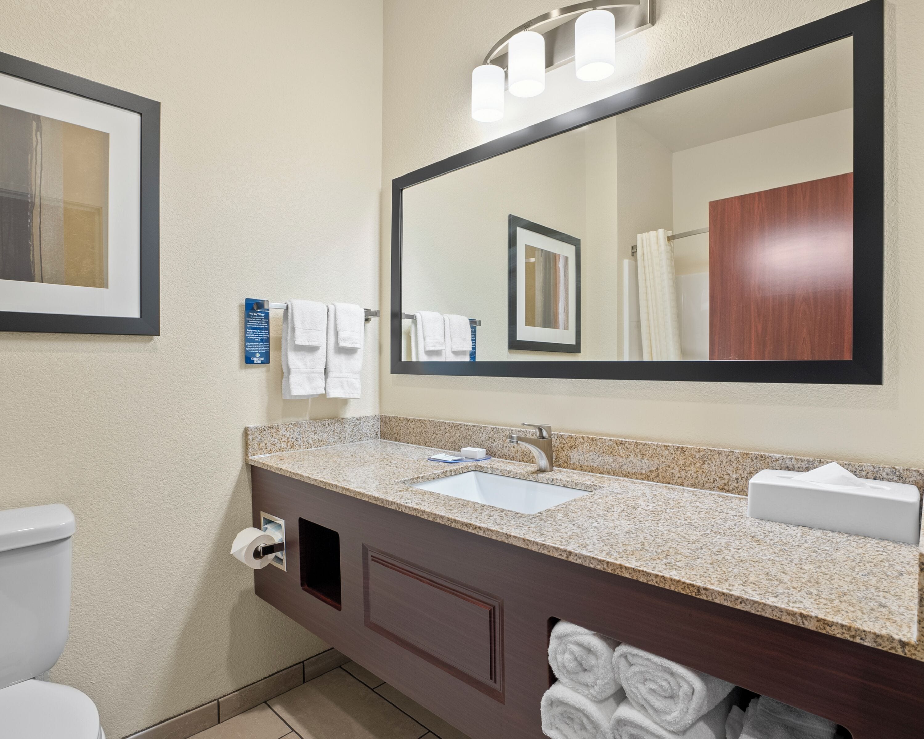 A bathroom with a sink, mirror, towel rack, and toilet.