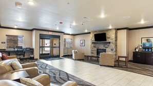 A spacious lobby with leather seating, a stone fireplace, a flat-screen TV, and a reception desk. - Cobblestone Hotel & Suites - Ephraim (Ephraim)