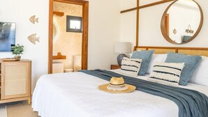 Una camera d'albergo con un letto, un comodino, uno specchio e una televisione.