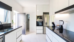 A modern kitchen with a built-in oven, a refrigerator, and a coffee maker. - GIL LOVE - Luxurious V5 w/ Pool by LovelyStay (Vila Nova de Gaia)