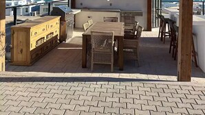 An outdoor patio with a wooden pergola, a grill, a dining table with chairs, and a view of the sea. - Luxury Villa w/Ocean views, Private Pool & Hot Tub. Steps from the beach! (San Felipe)