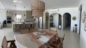 A spacious kitchen with a central island, dining area with a table set for six, and a living area with a sofa and coffee table. - Luxury Villa w/Ocean views, Private Pool & Hot Tub. Steps from the beach! (San Felipe)
